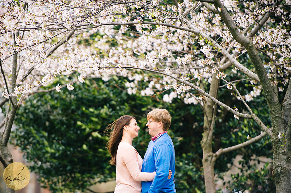 university of maryland engagement session couple hugging under cherry blossom tree