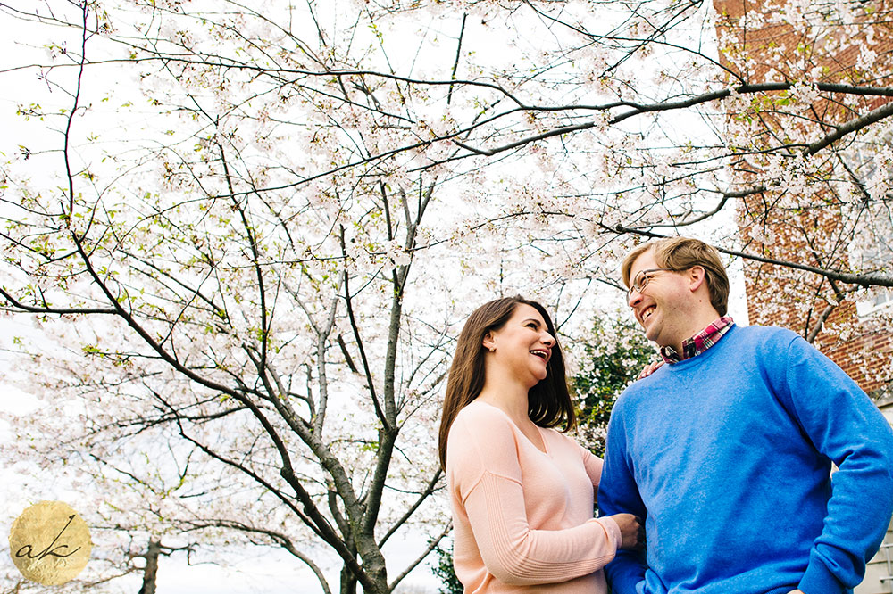 university of maryland college park spring engagement couple laughing standing under a flowering tree