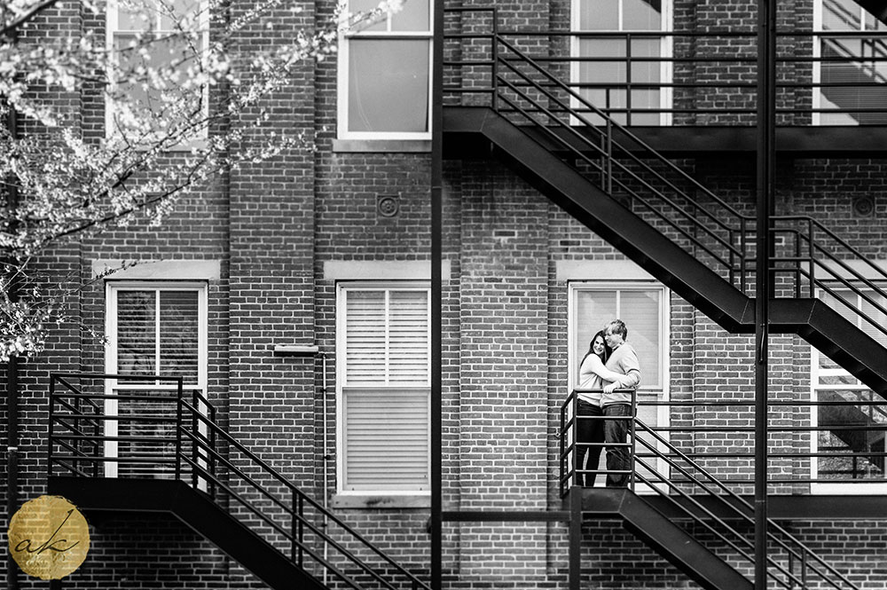 university of maryland spring engagement photos couple hugging on fire escape stairs