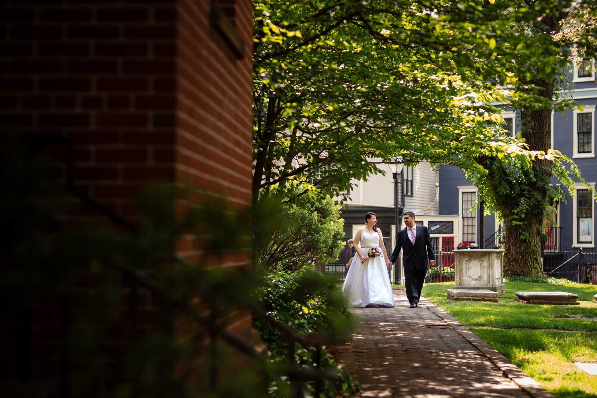 bride and groom walking down street by Washington DC wedding photographer Angel Kidwell