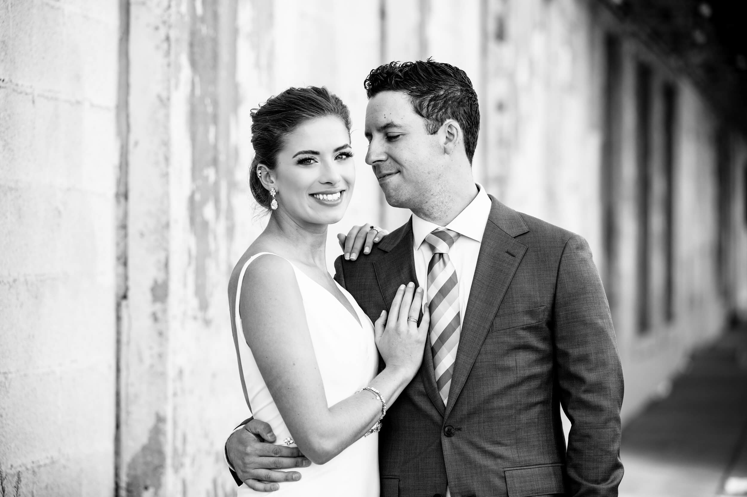 groom looks at smiling bride while embracing outside dc wedding