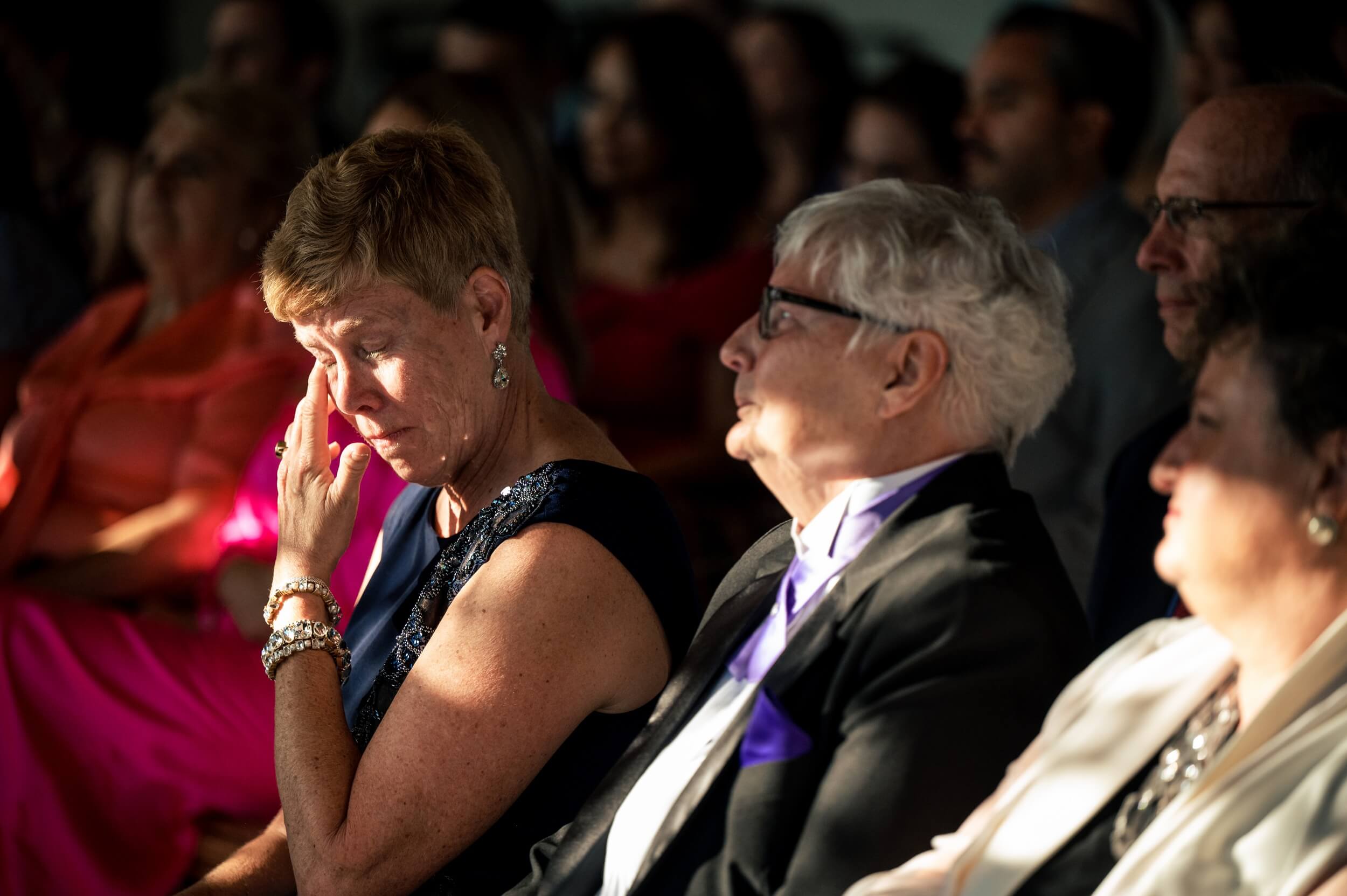 mother of the bride wipes tears away during ceremony at washington dc wedding