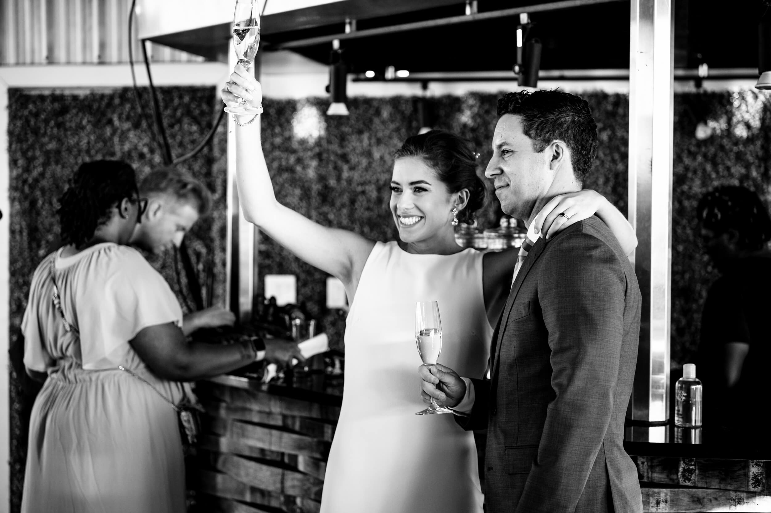 bride and groom toasting with champagne at washington dc rooftop wedding venue