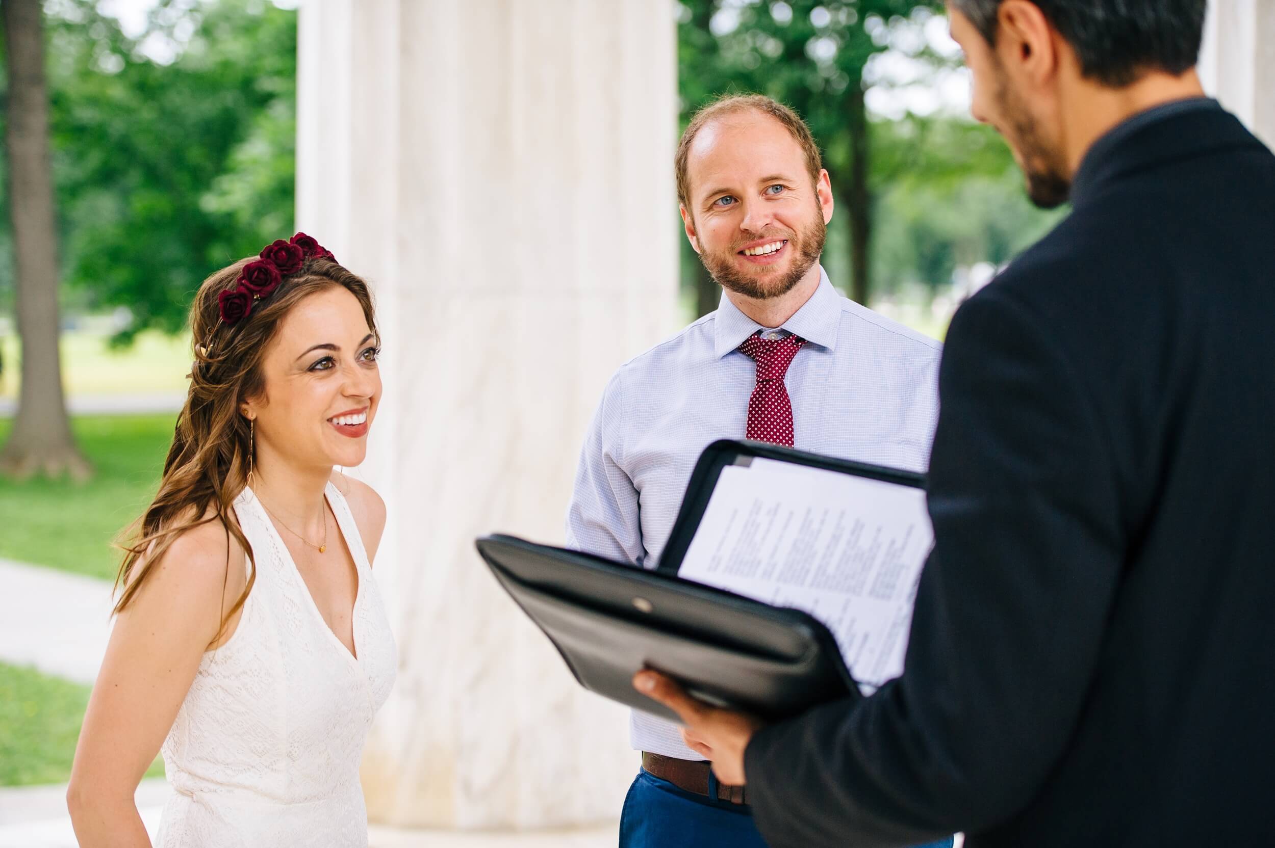 man and woman standing next to each other at the dc war memorial about to exchange vows