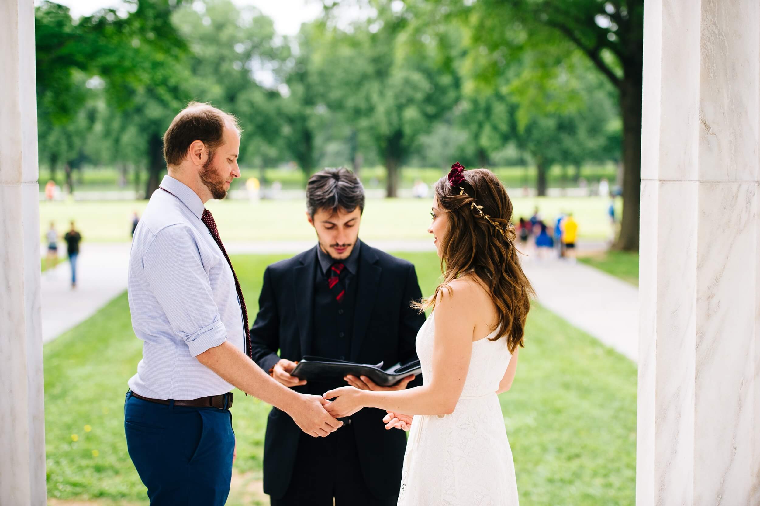 bride and groom holding hands exchanging vows at the dc war memorial