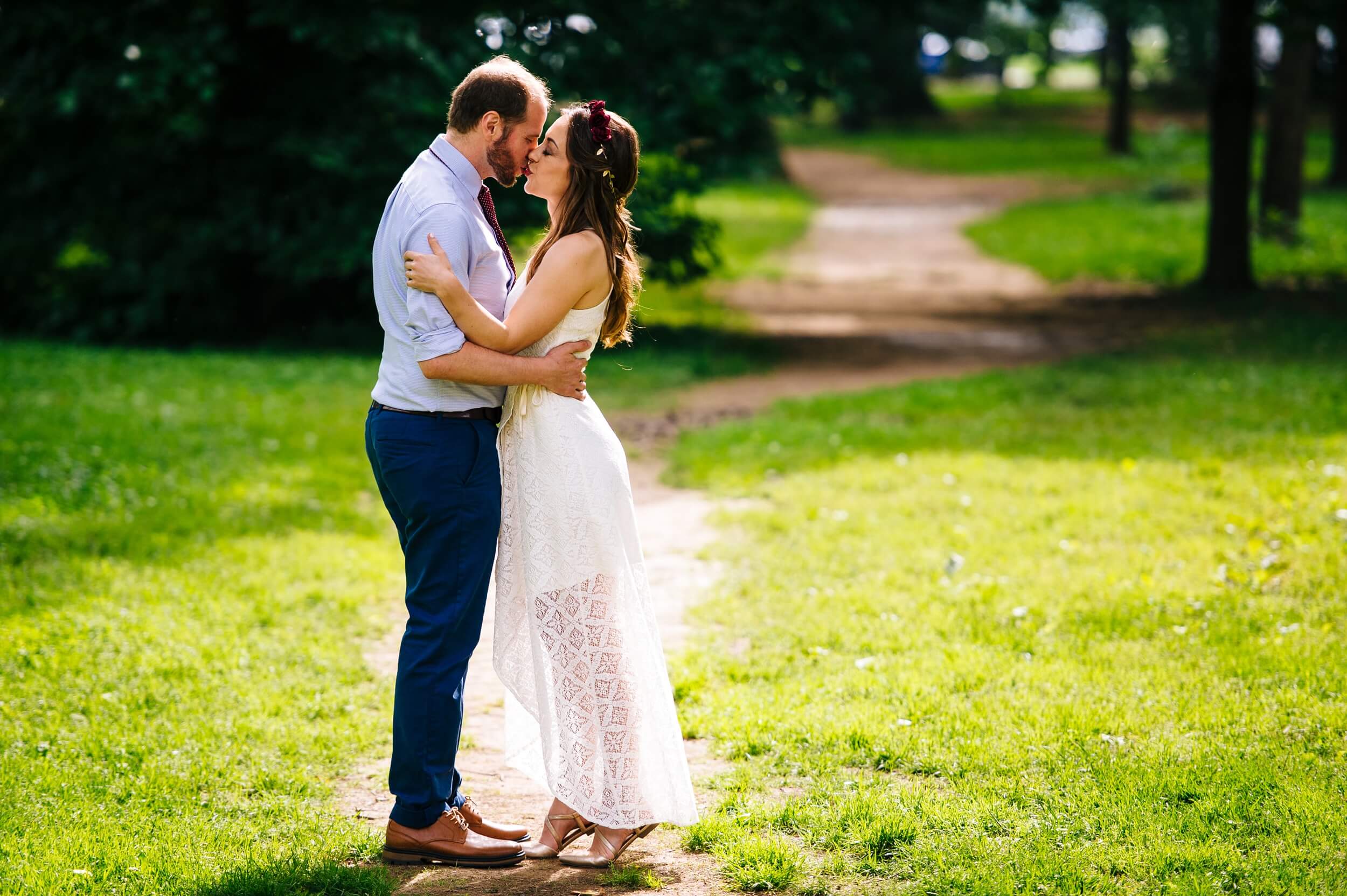 couple kissing with sunlight and greenery behind in washington dc