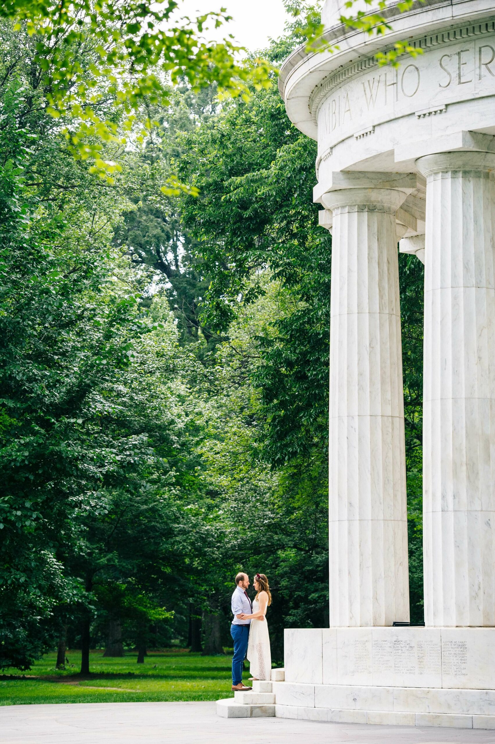 couple facing each other and holding hands on the steps of the dc war memorial