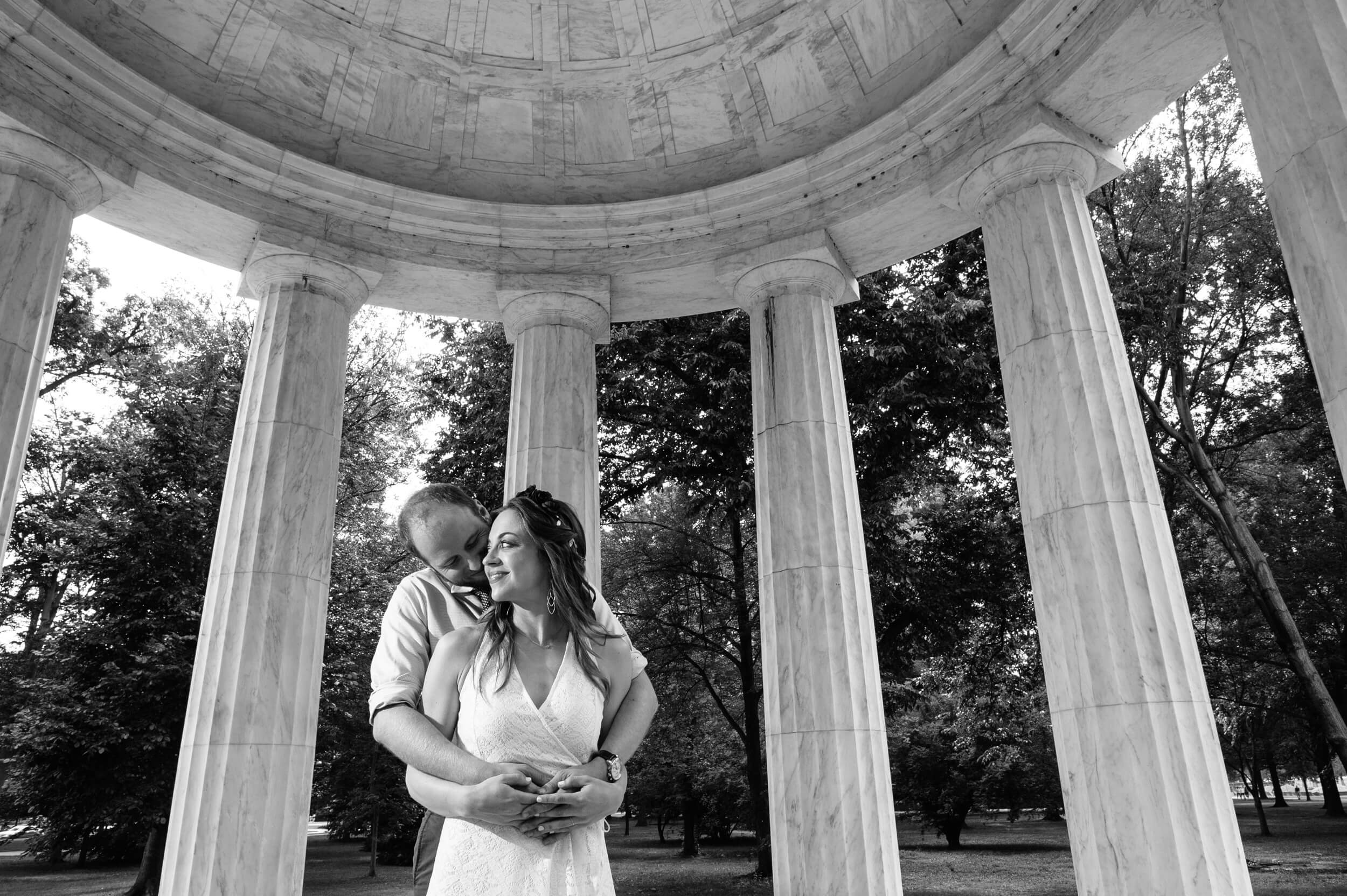 black and white photo of just married couple standing inside the dc war memorial